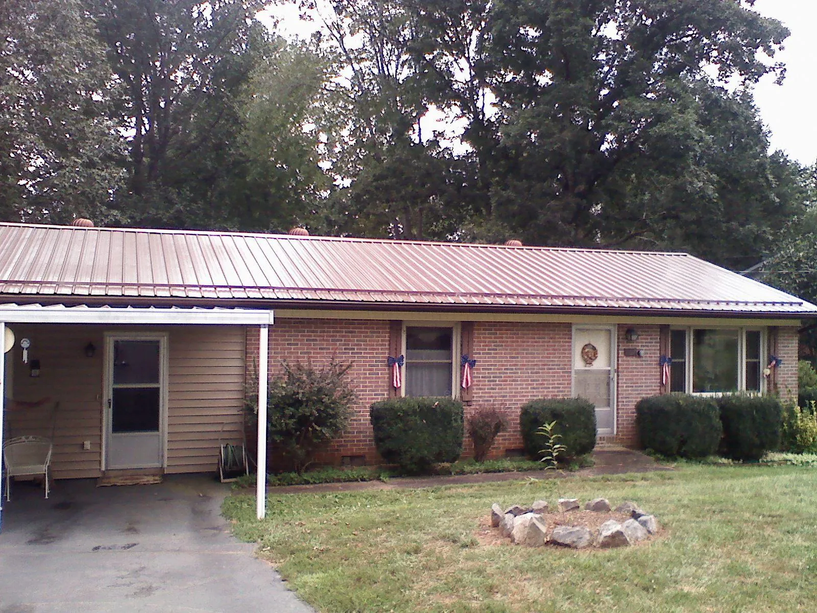 Bronze metal roof and carport on a brick ranch home — Roof Repair work by our crew in Trussville