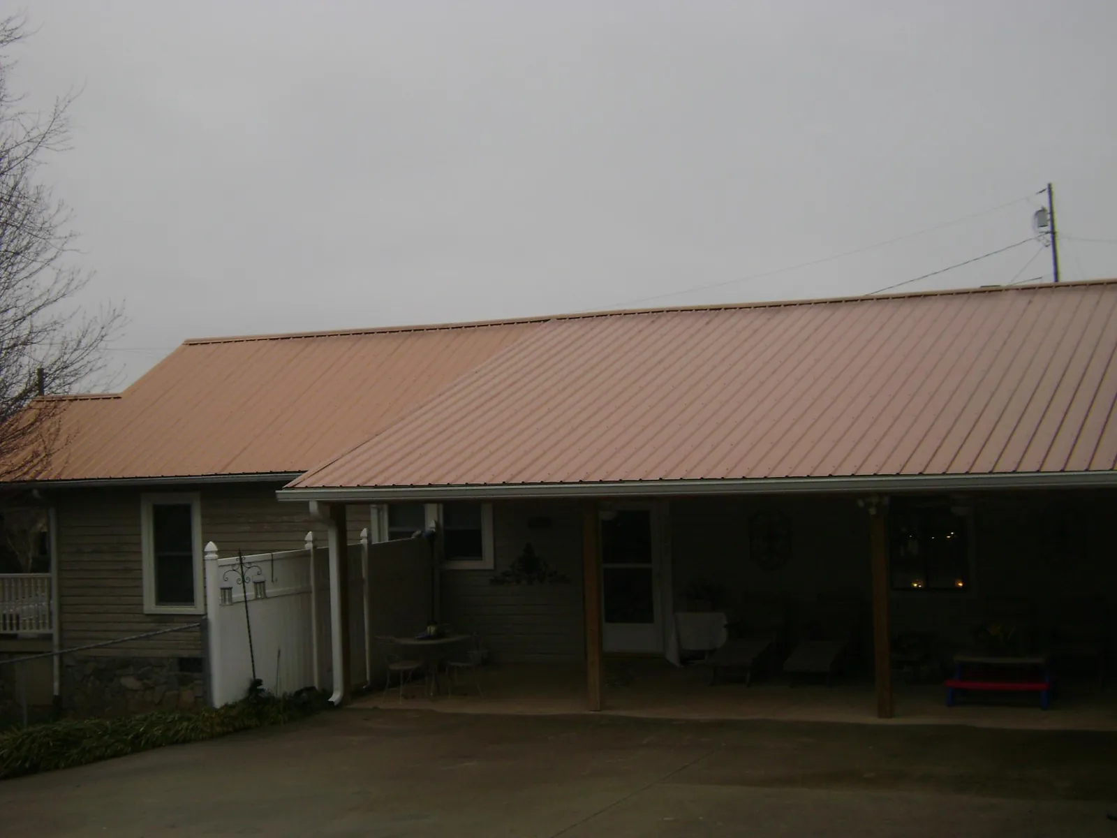 Copper toned metal roof over a wide covered patio in Trussville